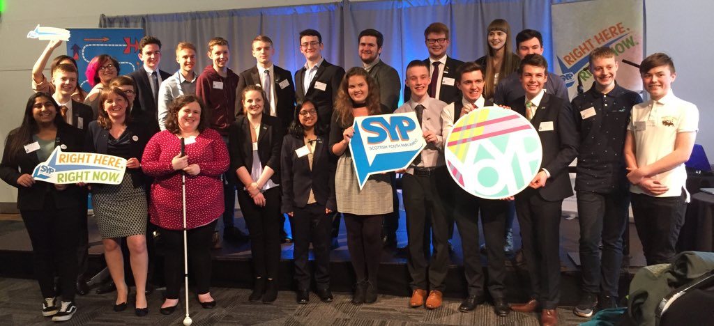 Around 30 MSYPs stand for a group photo with Maree Todd MSP with Right Here Right Now campaign branding