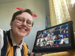 Erin Campbell MSYP takes a selfies holding a tablet with the Cabinet Takeover meeting on it.