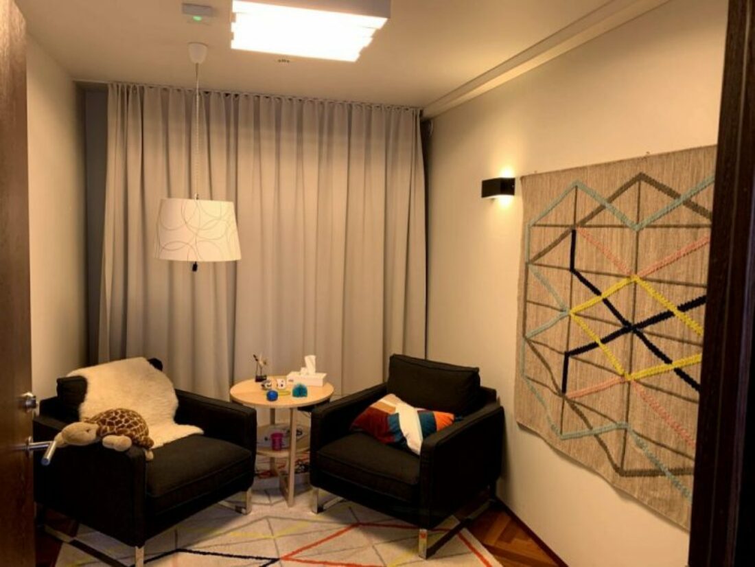 Two one seater sofas in the corner of a room face each other