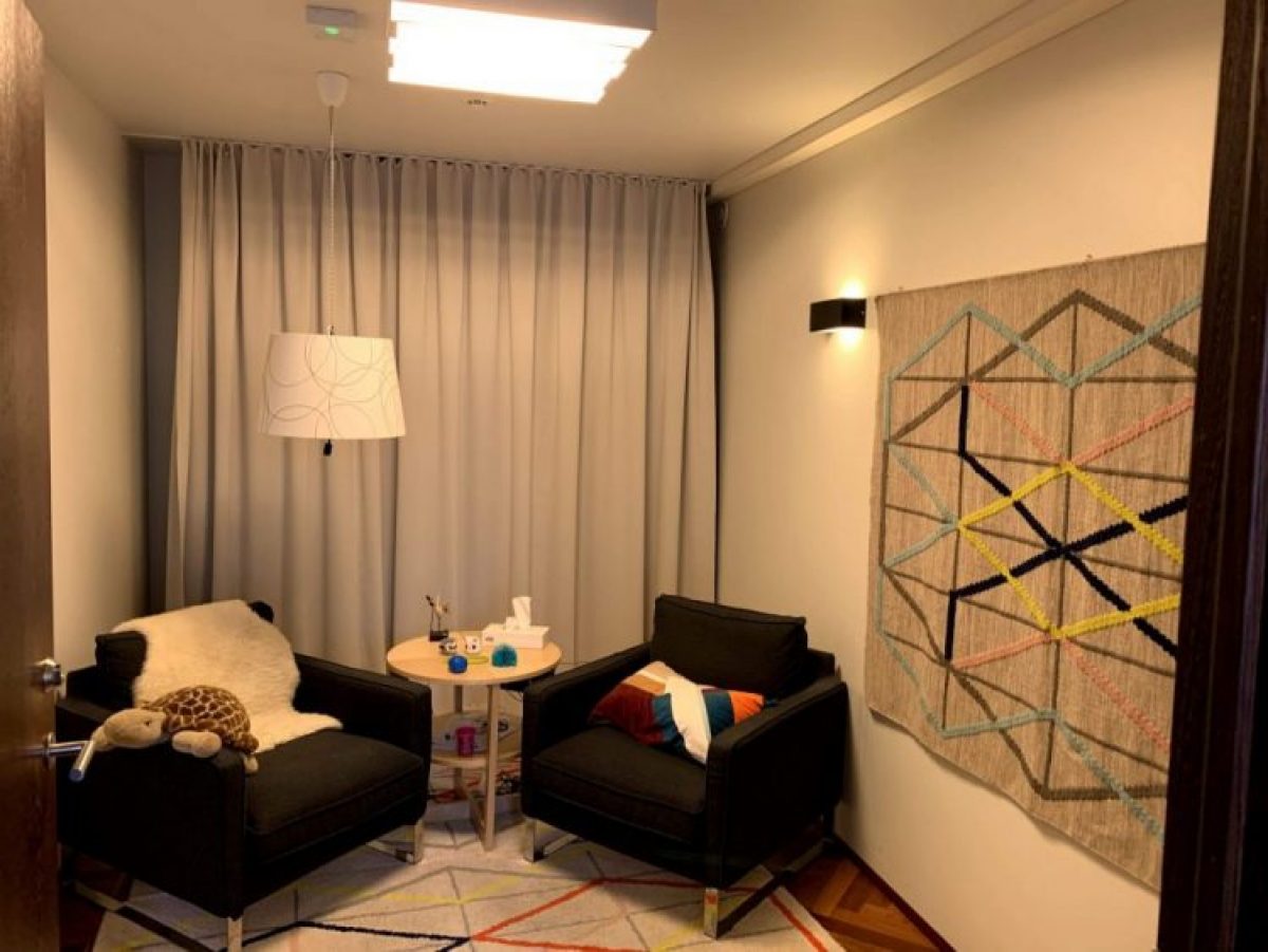 Two one seater sofas in the corner of a room face each other