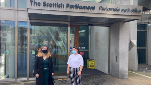 A picture of Erin Campbell MSYP and Wiktoria Orlikca MSYP standing at the entrance to the Scottish Parliament