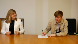 A picture of SYP's Chair, Josh Kennedy, and the Presiding Officer, Alison Johnstone, signing the SYP and Scottish Parliament partnership agreement