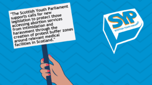 Blue patterned background with hand holding placard that reads: