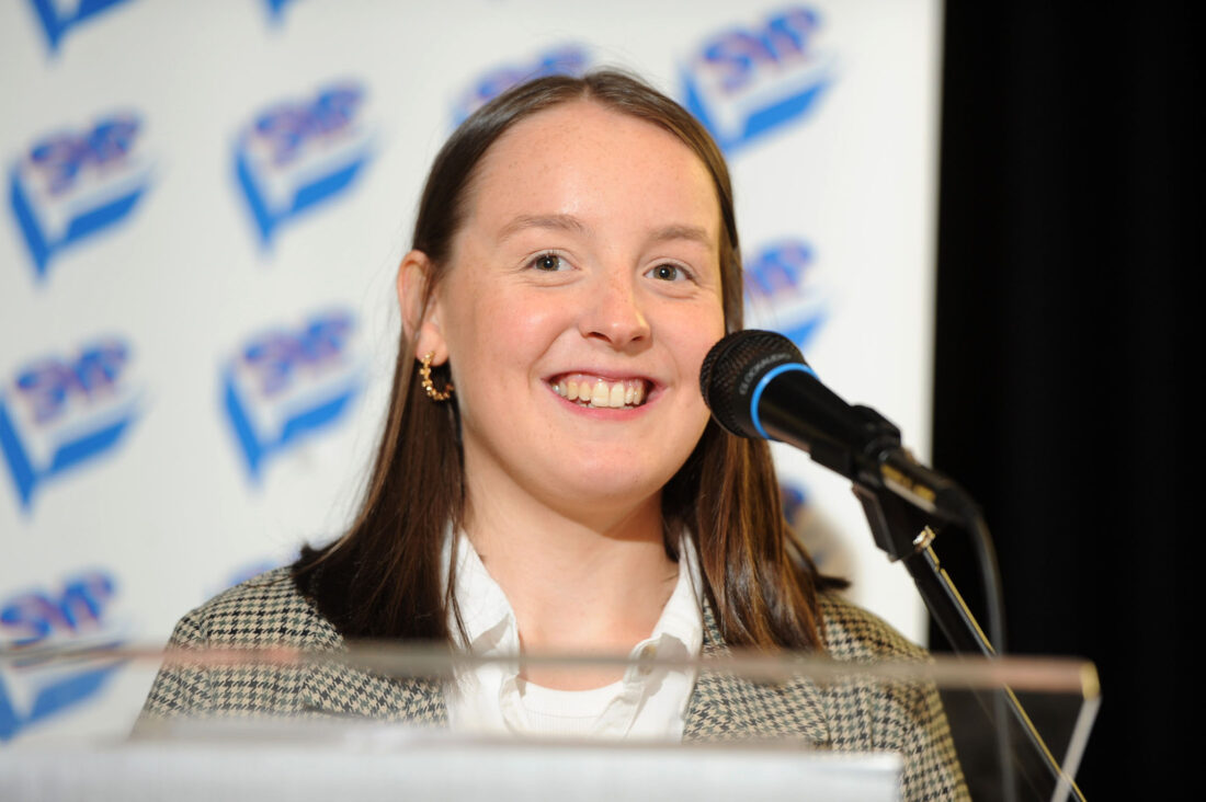 SYP Chair Sophie Reid MSYP on stage speaking at a lectern at SYP77