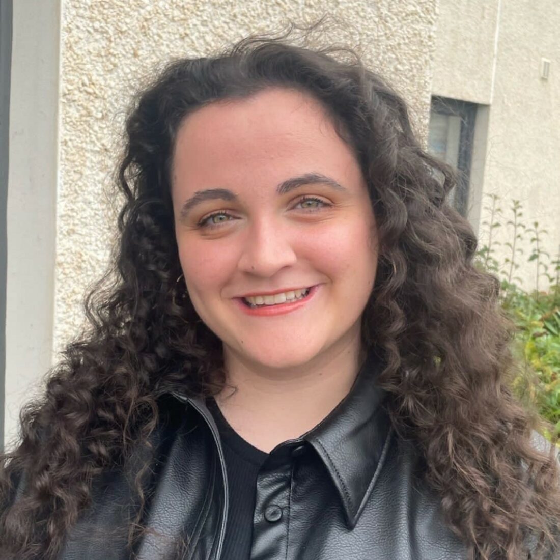 Shannon Donoghue smiling towards a camera wearing a black leather jacket